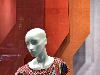 Close-up of mannequin against patterned wall