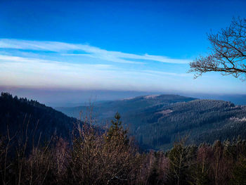 Scenic view of mountains against blue sky