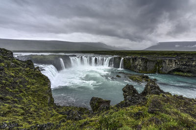Scenic view of waterfall against sky