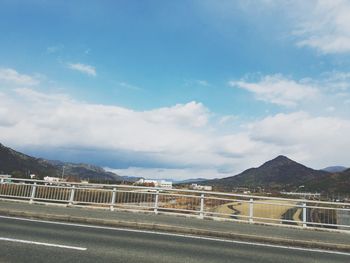 Road by mountain against sky