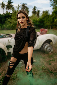 Portrait of beautiful young woman against trees