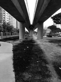 Empty road below bridge in city