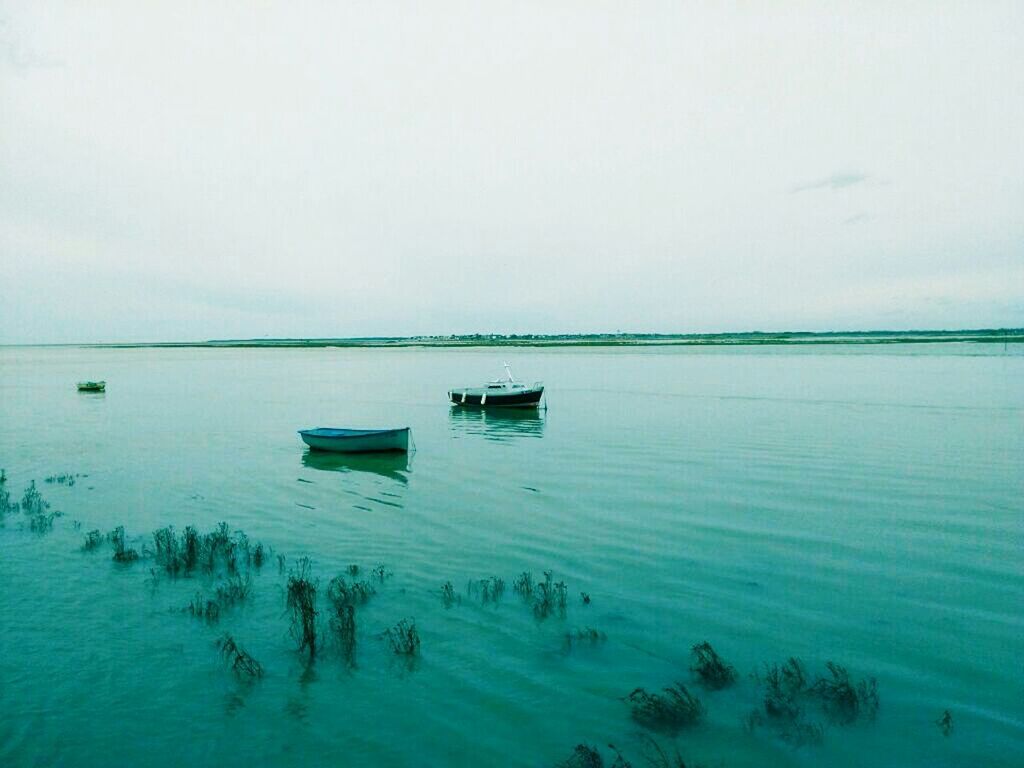 water, sea, nautical vessel, tranquil scene, tranquility, boat, horizon over water, transportation, beauty in nature, scenics, copy space, mode of transport, nature, waterfront, sky, blue, idyllic, calm, clear sky, moored