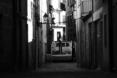 Small truck parked in the middle of a narrow street of the old town