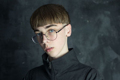 Portrait of young man against gray wall