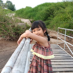 Side view portrait of girl standing on footbridge