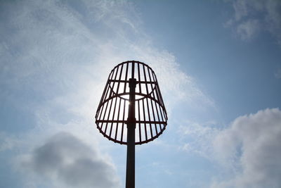 Low angle view of electric lamp against sky