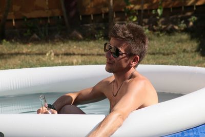 Man having drink while relaxing in wadding pool