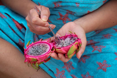 Midsection of woman holding dragon fruit 