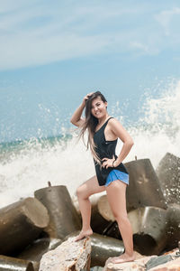 Full length portrait of woman by sea against sky