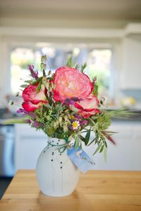 Close-up of flowers in vase on wooden table at home