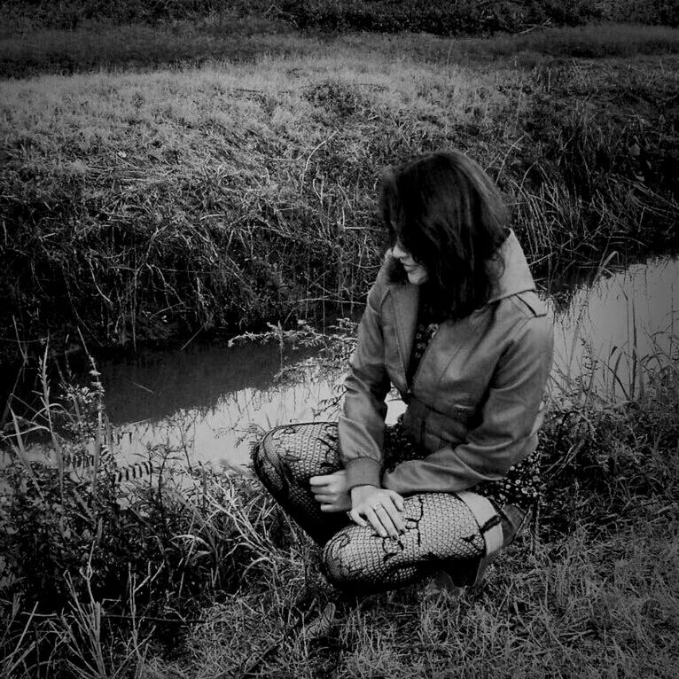 grass, lifestyles, leisure activity, water, rear view, casual clothing, full length, lake, sitting, nature, three quarter length, field, tranquility, relaxation, standing, men, childhood