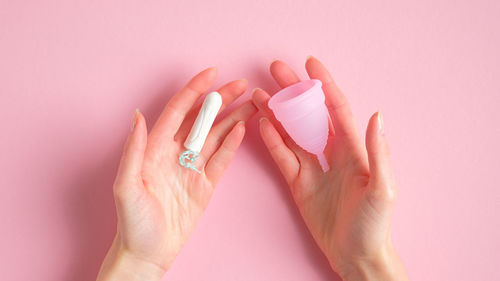 Close-up of woman hand holding pink flower