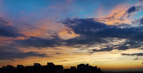 Low angle view of silhouette buildings against sky during sunset