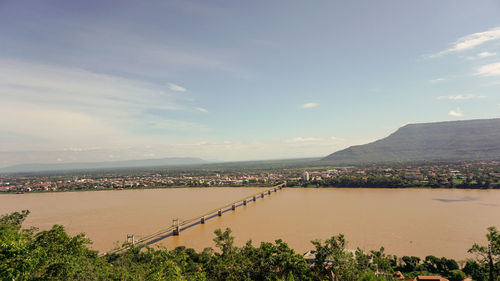 Scenic view of river by mountains against sky