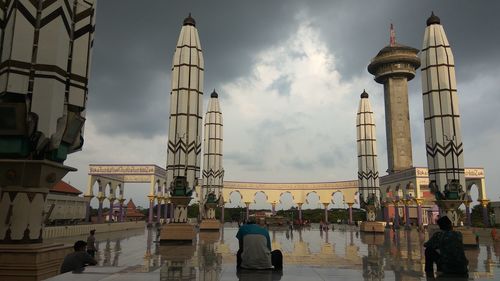 People at town square against sky in city