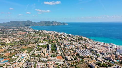 High angle view of townscape by sea against sky