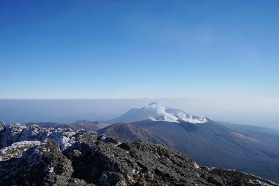 Scenic view of snowcapped mountains against clear blue sky