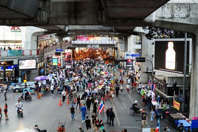 Group of people in market walking on street in city