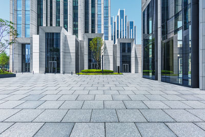 Footpath by modern buildings in city