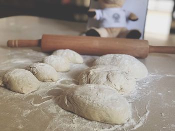 Close-up of dough on table by rolling pin on table