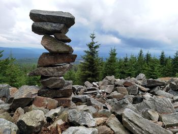 Stack of stones on rock against sky