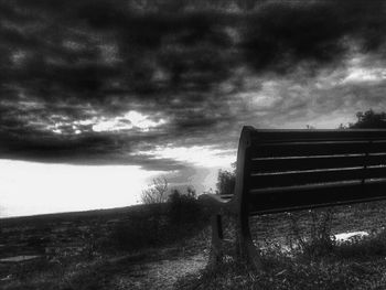 View of field against cloudy sky