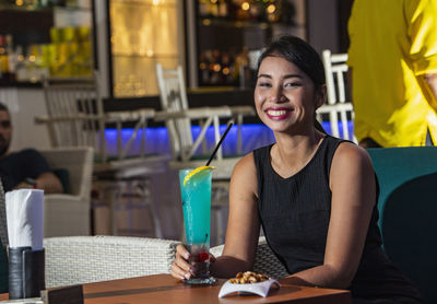 Beautiful woman enjoying cocktail at hotel bar in phuket