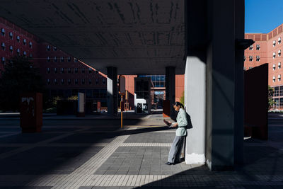 Working woman using laptop standing in downtown district