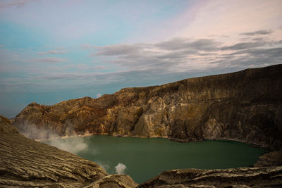 Scenic view of lake by mountains against sky