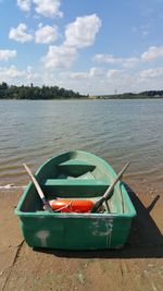 Boat moored in lake against sky