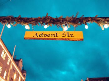 Low angle view of information sign against blue sky