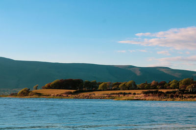 Scenic view of sea and mountains against sky