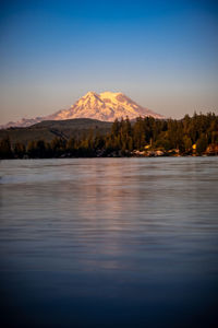 Scenic view of lake and mountains against blue sky