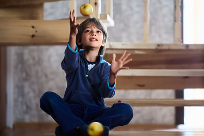 Portrait of boy playing with toy on wooden wall