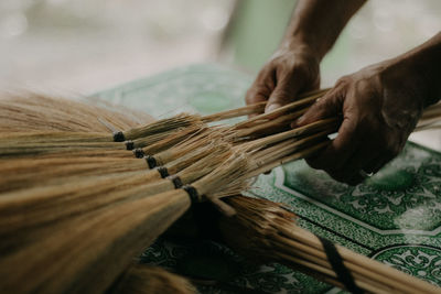 Close-up of person working on handcrafted walis tambo or brooms