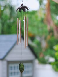 Close-up of hanging wind chimes in backyard 