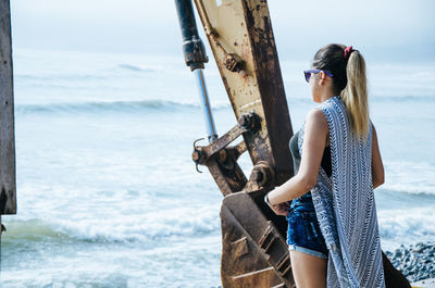 Full length of young woman at beach against sky