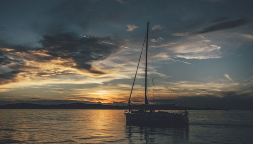 Sailboat on sea against sky during sunset