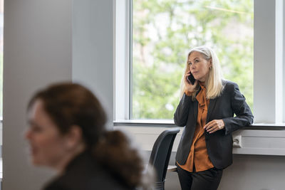 Businesswoman talking via cell phone in office