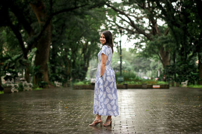 Full length portrait of woman standing in rain