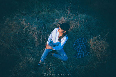 High angle view of young man sitting on field