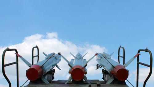 Low angle view of rockets against blue sky