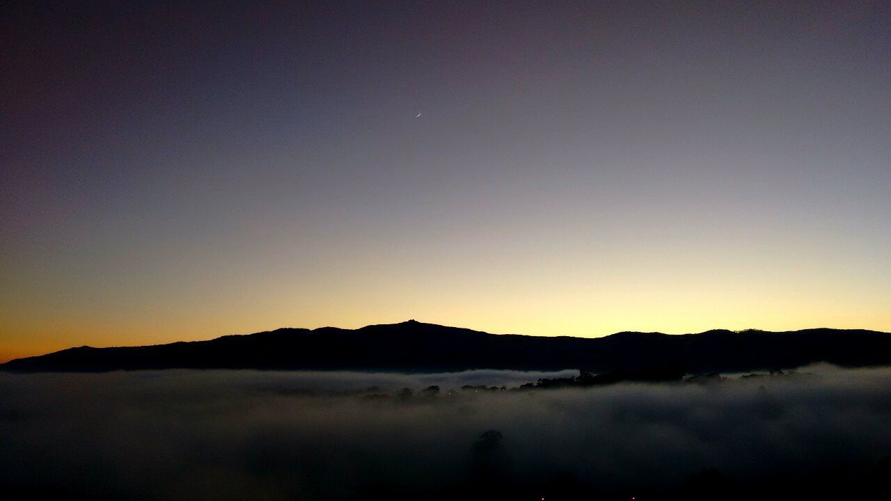 SCENIC VIEW OF SILHOUETTE MOUNTAIN AGAINST SKY AT SUNSET