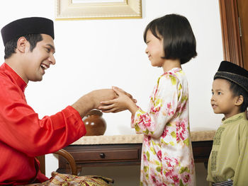 Father and daughter holding hands at home