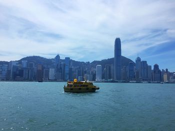 Boat in sea against buildings in city