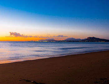 Scenic view of beach against sky during sunset