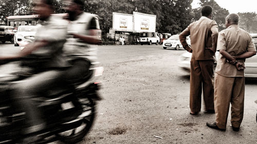 Group of people walking on road in city