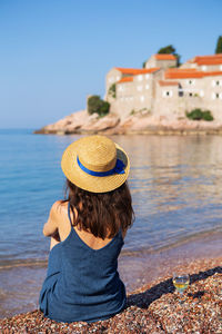 Rear view of woman looking at sea against sky