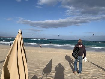 Full length of man standing on beach against sky